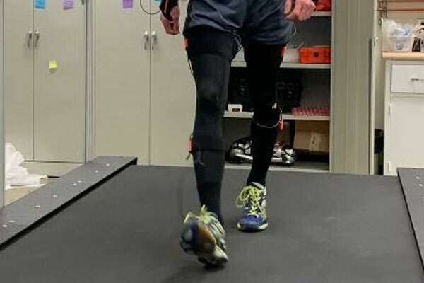 Researcher walking on a treadmill in XSens IMU motion capture suit.